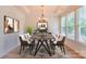 Bright dining room featuring modern chandelier, hardwood floors, and large windows that bring in natural light at 1012 Equipoise Dr, Indian Trail, NC 28079