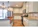 Modern kitchen with stainless steel appliances, wood floors and an island with a sink and faucet at 1012 Equipoise Dr, Indian Trail, NC 28079