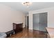 Well-lit bedroom featuring hardwood floors, a dresser, and a closet with gray doors, creating a stylish space at 1131 Doby Ct, Fort Mill, SC 29715