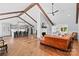 Open-concept living room featuring vaulted ceilings, exposed beams, brick fireplace and hardwood flooring at 1131 Doby Ct, Fort Mill, SC 29715