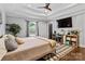 Comfortable main bedroom with tray ceilings, a ceiling fan, and a mounted television for relaxing at 1131 Doby Ct, Fort Mill, SC 29715