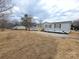 Attractive home with a spacious yard, featuring a light-colored exterior and complemented by a gravel driveway at 1170 Meadowcreek Dr, China Grove, NC 28023