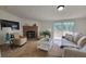 Comfortable living room with a stone fireplace, cozy seating, and a sliding door leading to an outdoor deck at 1170 Meadowcreek Dr, China Grove, NC 28023