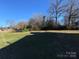 Expansive backyard featuring a lush lawn and mature trees, perfect for outdoor activities at 128 Cromer St, Charlotte, NC 28208