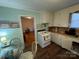 A cozy kitchen featuring white cabinets, wood-look flooring, and space for a small table at 128 Cromer St, Charlotte, NC 28208