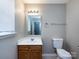 Clean bathroom featuring a vanity, mirror, and toilet, illuminated by a modern light fixture at 12915 Deaton Hill Dr, Charlotte, NC 28269
