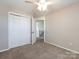 The bedroom has neutral walls, carpet and ceiling fan at 12915 Deaton Hill Dr, Charlotte, NC 28269