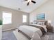 Staged bedroom with natural light, ceiling fan, and a comfortable bed with stylish decor at 12915 Deaton Hill Dr, Charlotte, NC 28269