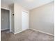 This bedroom features neutral paint, carpet flooring and a double door closet at 12915 Deaton Hill Dr, Charlotte, NC 28269