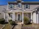 Close-up view of a charming front porch with classic columns and an oval window detail at 12915 Deaton Hill Dr, Charlotte, NC 28269