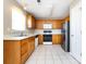Efficient kitchen setup with wood cabinets, white appliances, and tile flooring at 12915 Deaton Hill Dr, Charlotte, NC 28269