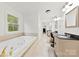 Bright bathroom with large tub, double sink vanity, and natural light from window at 1335 Blacksnake Rd, Stanley, NC 28164