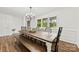 A dining room with white wainscoting, a decorative chandelier and a long dining table at 1335 Blacksnake Rd, Stanley, NC 28164