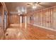 Empty bedroom with wood-paneled walls, flooring, and a closet for easy storage and organization at 136 Coble Ave, Albemarle, NC 28001