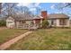 Charming single-story home with a brick chimney, accessible ramp, and welcoming front porch at 136 Coble Ave, Albemarle, NC 28001