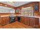 Vintage style kitchen with wooden cabinets, pink countertops, updated appliances, and natural light at 136 Coble Ave, Albemarle, NC 28001