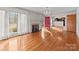 Open living area with hardwood flooring, fireplace, large windows, and smooth access to another room at 136 Coble Ave, Albemarle, NC 28001