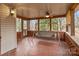 A covered porch with red brick flooring and a swing, perfect for relaxing outdoors at 136 Coble Ave, Albemarle, NC 28001