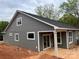 New home showcasing gray siding, white trim, covered patio, and well-lit exterior at 140 First St, Huntersville, NC 28078