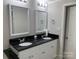 A bathroom with a double vanity, black granite countertop, and updated mirrors at 150 Twisted Oak Ln, Gastonia, NC 28052