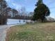 Charming single-story home with a gravel driveway, grassy yard, and mature trees at 150 Twisted Oak Ln, Gastonia, NC 28052