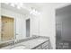 This bathroom features double sinks with granite counters, large mirrors, and a shower with tub at 15119 Oleander Dr, Charlotte, NC 28278