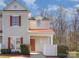 Charming townhome featuring red shutters, a cozy front porch with a vibrant red door, and fresh landscaping at 1751 Holliford Ct, Charlotte, NC 28215