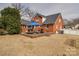 A brick home featuring a patio with an umbrella, a lush green lawn and a white picket fence at 204 Julia Ave, Belmont, NC 28012