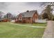 A charming brick home with a lush green lawn, complemented by a white picket fence at 204 Julia Ave, Belmont, NC 28012