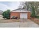 Detached brick garage featuring a white door, workbench, and concrete driveway at 204 Julia Ave, Belmont, NC 28012