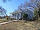 Charming blue brick home featuring a welcoming front porch and landscaped front yard at 2046 Cartier Way, Charlotte, NC 28208