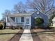 Charming blue brick home featuring a welcoming front porch and landscaped front yard at 2046 Cartier Way, Charlotte, NC 28208