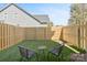 Private backyard with artificial grass, cozy seating, and secure wooden fence at 206 Freeland Ln, Charlotte, NC 28217