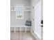 Bright entryway featuring a modern frosted door, bench, shelves and natural light at 206 Freeland Ln, Charlotte, NC 28217