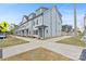 New townhome build featuring cement sidewalks, gray siding, black shutters, and roof dormers at 206 Freeland Ln, Charlotte, NC 28217