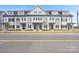 Row of modern townhouses exhibiting consistent design, curb appeal, and neat landscaping at 206 Freeland Ln, Charlotte, NC 28217