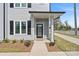 Charming front entryway with a black door, manicured landscaping, and sleek exterior design at 206 Freeland Ln, Charlotte, NC 28217