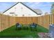 Cozy backyard featuring artificial grass, a wood fence, and outdoor seating; perfect for relaxing or entertaining at 210 Freeland Ln, Charlotte, NC 28217
