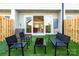Inviting backyard with artificial grass, patio seating, and a sliding glass door leading to the home's interior at 210 Freeland Ln, Charlotte, NC 28217