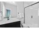 Modern bathroom showcasing a tiled shower with glass door, toilet, and vanity at 210 Freeland Ln, Charlotte, NC 28217