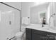 Modern bathroom showcasing a tiled shower with glass door, toilet, and vanity at 210 Freeland Ln, Charlotte, NC 28217