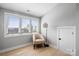 Bright bedroom featuring natural light, chair, and light hardwood flooring throughout at 210 Freeland Ln, Charlotte, NC 28217