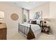 Cozy bedroom with a metal frame bed, neutral walls, soft lighting, and a window overlooking a lush, green view at 2227 Indigo Branch Rd, Indian Land, SC 29707