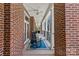 Relaxing porch with brick columns, ceiling fans, rocking chair, and blue rug at 2251 Selwyn Ave # 201, Charlotte, NC 28207