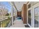 Long covered porch with brick columns, ceiling fans, rocking chairs, and blue accent rug at 2251 Selwyn Ave # 201, Charlotte, NC 28207