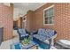 Covered porch with brick columns, ceiling fan, and cozy outdoor seating area at 2251 Selwyn Ave # 201, Charlotte, NC 28207