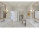 Well-lit bathroom showcasing marble floors, double sink vanities, and private toilet area at 2251 Selwyn Ave # 201, Charlotte, NC 28207