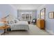 A beautifully designed primary bedroom with soft blue walls, bright windows, and a wood chest at 2251 Selwyn Ave # 201, Charlotte, NC 28207