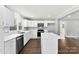 Bright kitchen featuring white cabinets, stainless steel appliances, an island and hardwood floors, open to living room at 228 Tot Dellinger Rd, Cherryville, NC 28021