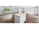 Modern kitchen island with white cabinets and quartz counters, hardwood floors, with a partial view of the living area at 228 Tot Dellinger Rd, Cherryville, NC 28021